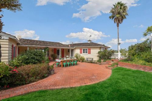 a house with a patio with a table in the yard at The Porter House - Sweeping Ocean Views - La Jolla in San Diego