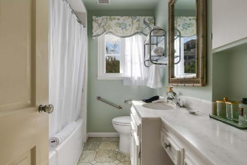 a bathroom with a sink and a toilet and a mirror at The Porter House - Sweeping Ocean Views - La Jolla in San Diego