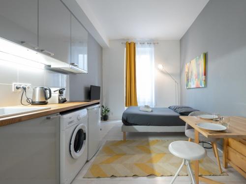 Il comprend une cuisine et un salon avec un lit et une table. dans l'établissement Le Nid Lyonnais - Montchat, à Lyon