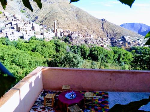 a view of a city from a balcony with a table at Gîte akioud mazik in Imlil