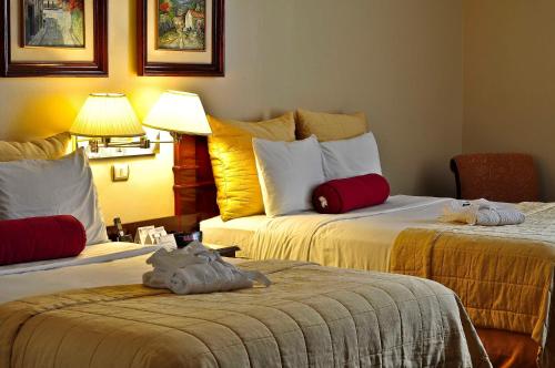 a hotel room with two beds with stuffed animals on them at Clarion Hotel San Pedro Sula in San Pedro Sula