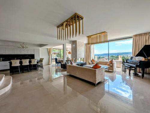 un grand salon avec un canapé et une cuisine dans l'établissement Villa Romarin St Paul de Vence, à Saint-Paul-de-Vence