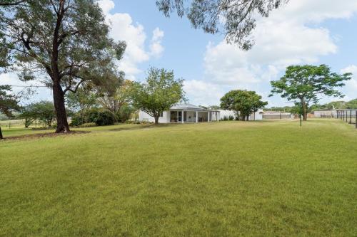 a large yard with a house in the background at Wisteria Cottage Rylstone in Rylstone