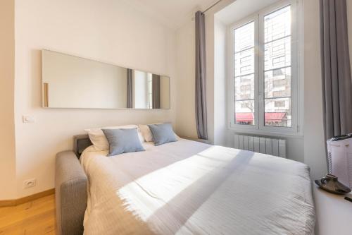 une chambre avec un grand lit avec un grand miroir dans l'établissement Le Carré d'Or - à 2 min à pied du centre-ville, à Nice