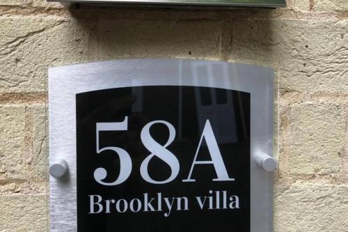 a sign on the side of a brick wall at Brooklyn Villa in Norwich