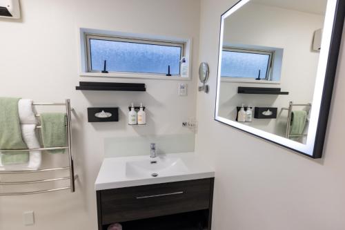 a bathroom with a sink and a mirror at The Milano Christchurch in Christchurch