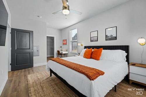 罗杰斯Luxuary Apt, Pool, Kingbeds, Near Amp的卧室里有一张白色的大床，上面放着橙色的枕头