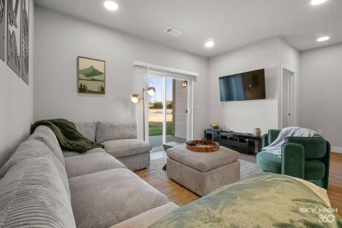 a living room with a couch and chairs and a tv at Exec King Suites Pool, Gym, Walmart Hq,gym in Rogers