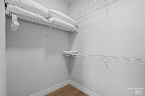 a closet with white walls and a shelf with towels at Exec King Suites Pool, Gym, Walmart Hq,gym in Rogers
