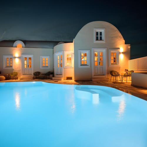 a large swimming pool in front of a house at night at MyBoZer Hotel Kallisto in Imerovigli