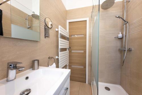 une salle de bain avec un lavabo blanc et une douche dans l'établissement Le Carré d'Or - à 2 min à pied du centre-ville, à Nice