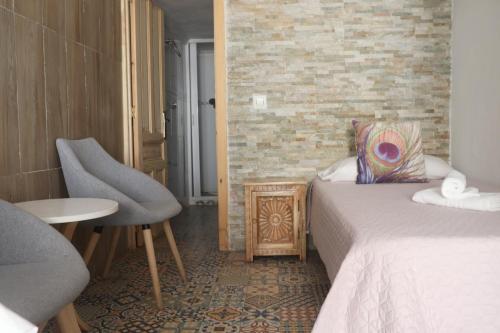 a hotel room with a bed and a table and a chair at Hostal La Paloma I in Calpe