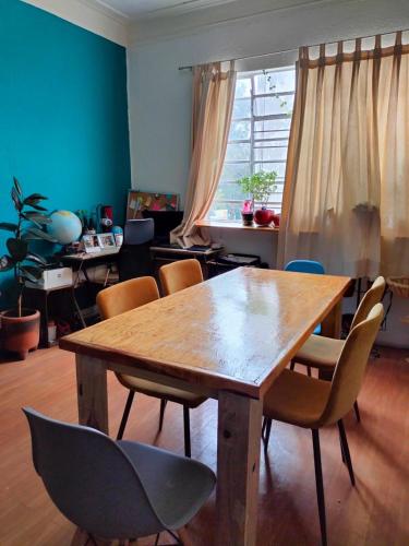 ein Esszimmer mit einem Holztisch und Stühlen in der Unterkunft Linda Habitación en Centro Histórico en Ciudad de Mexico in Mexiko-Stadt