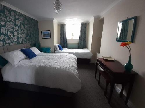 a hotel room with two beds and a window at Talarfor Barmouth in Barmouth