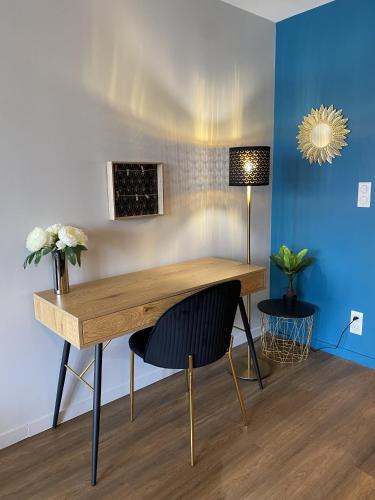 un bureau avec une chaise et un mur bleu dans l'établissement Marianne 2, à Bergerac