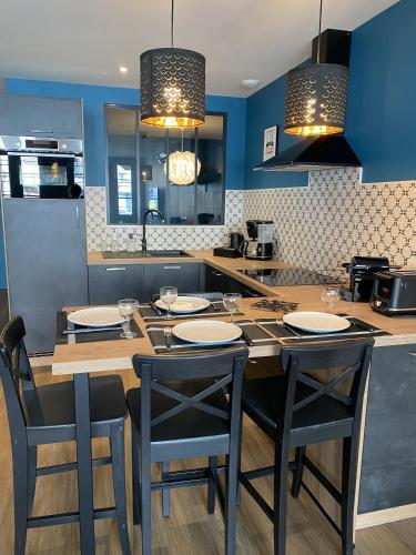 une cuisine avec une table et des chaises et une cuisine aux murs bleus dans l'établissement Marianne 2, à Bergerac