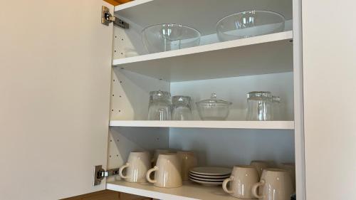 a cupboard filled with dishes and glass jars at Dwór Piotra i Pawła- pokoje i domki in Miedzygorze
