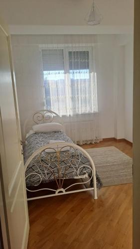 a bedroom with a bed in a room with a window at Аэропорт Апартаменты Комфорт in Chişinău