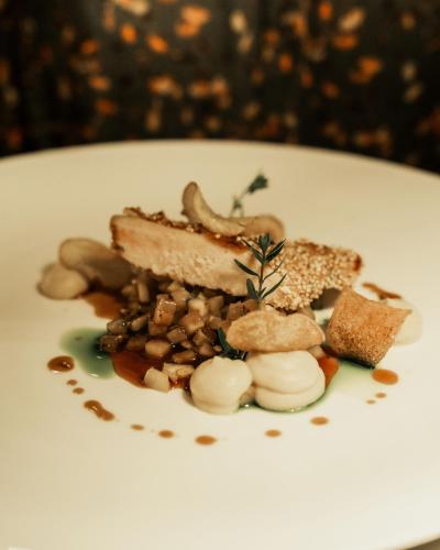 a white plate with a piece of cake and nuts at Hotel Bad Fallenbach in San Leonardo in Passiria