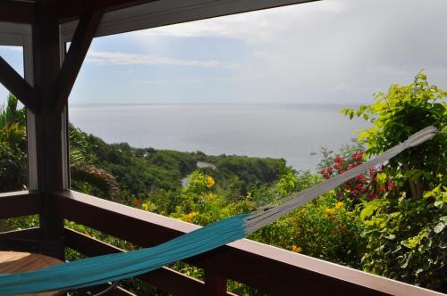 a hammock overlooking the ocean from a house at Infiniti Blue in Bouillante