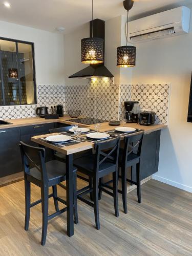 une cuisine avec une table et des chaises noires dans l'établissement Marianne 3, à Bergerac
