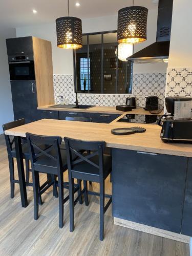 une cuisine avec une table en bois et des chaises noires dans l'établissement Marianne 3, à Bergerac