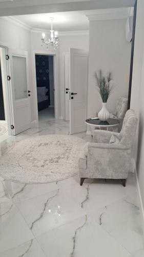 a white living room with a couch and a table at Аэропорт Апартаменты Комфорт in Chişinău