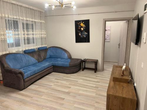 a living room with a blue couch and a table at Apartament Marieva 1 in Craiova