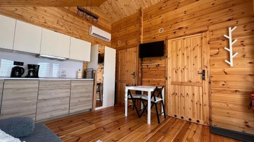 a kitchen with a table and a wooden wall at Dwór Piotra i Pawła- pokoje i domki in Miedzygorze