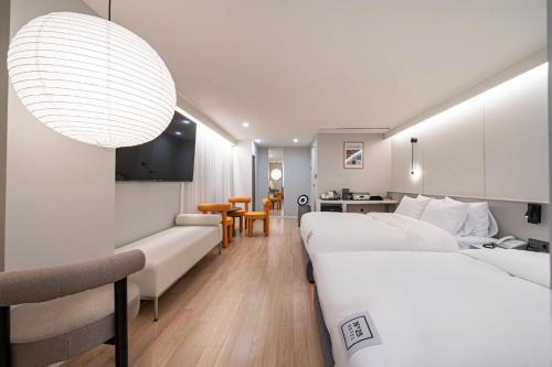 釜山にあるNo 25 Hotelのベッド2台とリビングルームがあるホテルの部屋