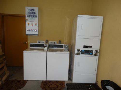 two white refrigerators sitting next to each other in a room at Regency Inn & Suites - Baytown in Baytown