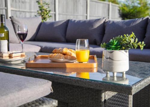 a coffee table with a tray of bread and wine glasses at 4x Bed Luxurious Home With a View in Downham Market