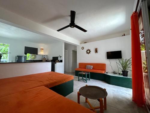 a bedroom with a bed and a couch and a tv at NEW MORINGA in Las Terrenas