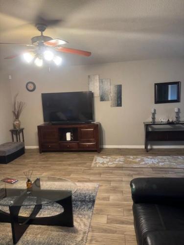 a living room with a couch and a flat screen tv at House 8122 in Humble
