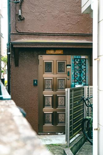 a door of a building with a gate in front at Rooftop Haven 新小岩 in Tokyo