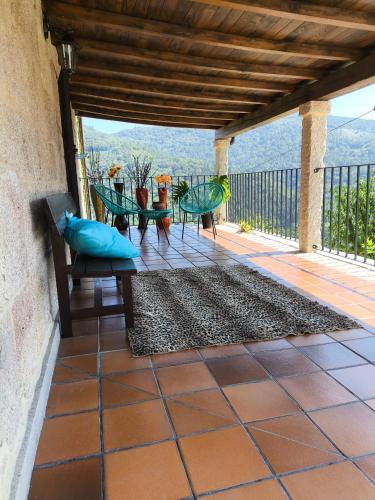 a patio with a table and chairs on a balcony at Xiravai-Ribeira Sacra in Peares