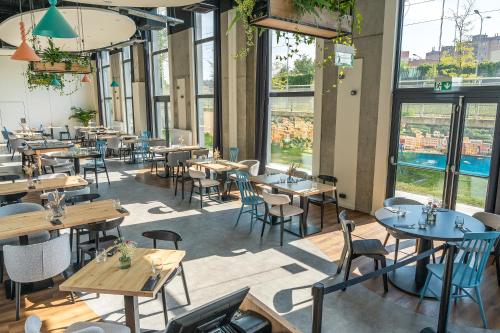 a restaurant with tables and chairs and windows at Hotel Convictus Cracovia for business & travellers in Kraków