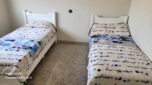 a bedroom with a bed with a comforter on it at résidence bouylaghman in Monte ʼArrouit