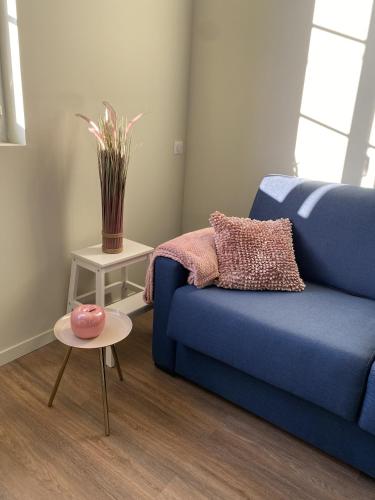 un salon avec un canapé bleu et une table dans l'établissement Marianne 6, à Bergerac