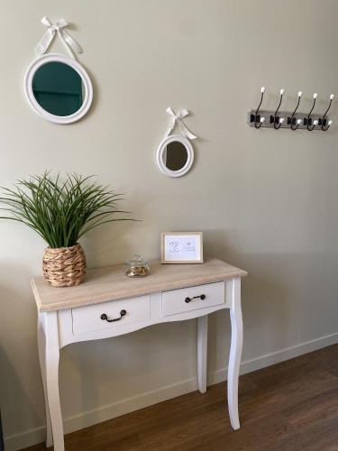 une coiffeuse blanche avec une plante en pot dans l'établissement Marianne 6, à Bergerac