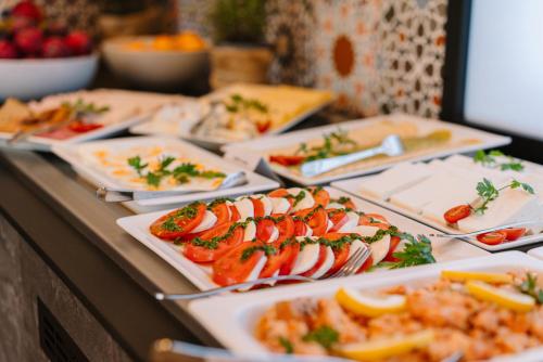 a buffet with plates of food on a table at Hotel Convictus Cracovia for business & travellers in Kraków