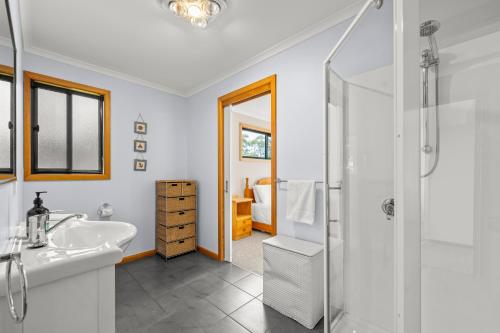 a bathroom with a shower and a sink at The Shack Port Arthur in Port Arthur