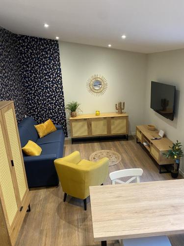 un salon avec un canapé bleu et un fauteuil jaune dans l'établissement Marianne 8, à Bergerac