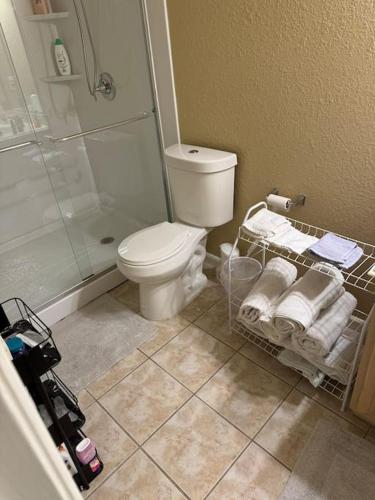 a bathroom with a toilet and a shower and towels at House 8122 in Humble
