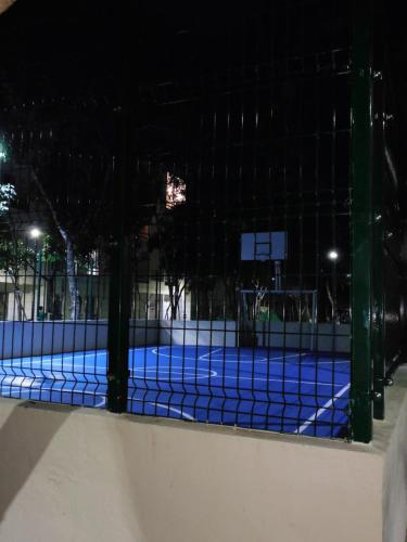 a tennis court behind a fence at night at Gigi's Caribbean Paradise Aparment in Playa del Carmen