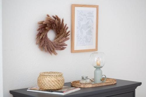 a table with a candle and a wreath on a wall at Ferienwohnung Fehmarn "FeWoFe" in Westfehmarn
