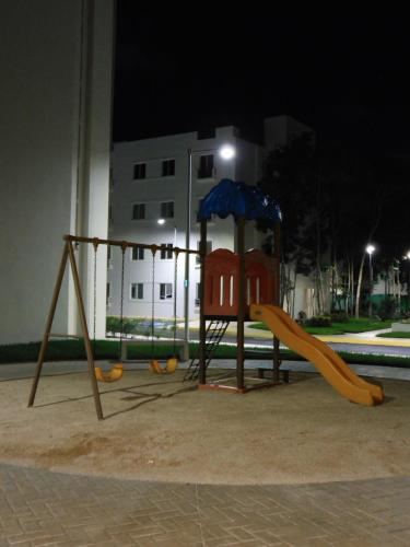 a playground at night with a slide and swings at Gigi's Caribbean Paradise Aparment in Playa del Carmen