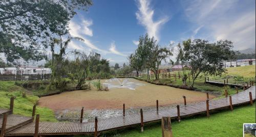 a park with a pond in the middle of a field at Rancho Las Santas in Guasca