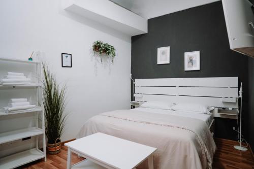 a bedroom with a white bed and a black wall at Bonne Nuit Terracina in Terracina