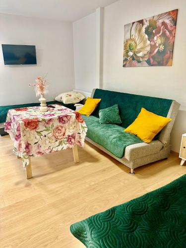 a living room with a green couch and a table at Apartament nr 1 lub 2 przy Sali Kominkowej in Przeczyce